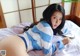 A woman laying on top of a bed in a blue and white striped sweater.
