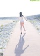 A woman walking down a path on the beach.