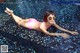 A woman in a pink bikini laying on the edge of a pool.