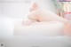 A woman laying on top of a bed in a white underwear.