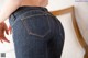 A woman in a pair of jeans with her back to the camera.