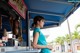 A woman standing in front of a food stand.