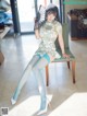 A woman sitting on a chair holding a fan.